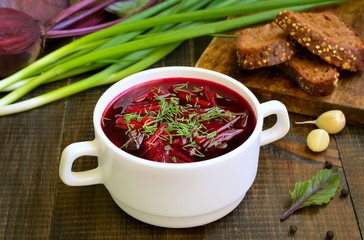 Red borscht soup with dill in white bowl