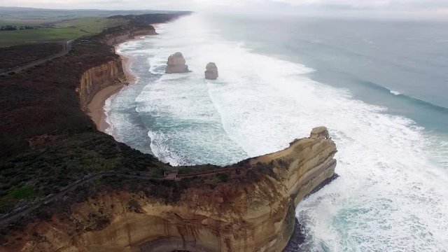 Horizontal aerial pan across twelve apostles lookout and Gog Magog rock formations. Great Ocean Road, Victoria, Australia.