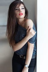 beautiful sexy girl with long dark hair rocker style with red lipstick on gubyh standing near a...