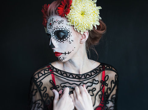 photo portrait of a girl with a pattern on the face and flowers in her hair Los Muertos