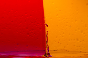 Drops, sprays, splashes of water on a colorful background