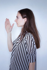 photo portrait of a girl in a striped shirt hand to his mouth in profile