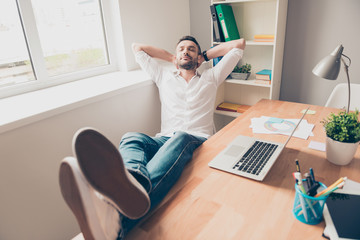 Relaxed happy man sleeping with legs on table