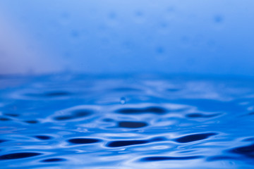Drops, sprays, splashes of water on a colorful background