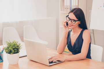 Portrait of successful smiling businesswoman talking  on phone w