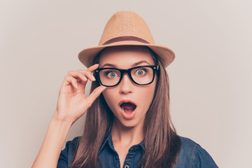 Shocked pretty woman in hat and glasses with open mouth