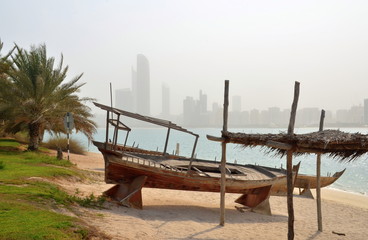 View on Abu Dhabi skyline with traditional boat in forefront, UAE
