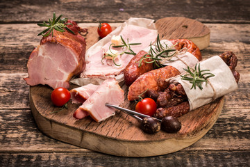 Antipasto catering platter with salami and meat on a wooden background