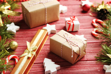 Christmas tree branch with baubles, candies on red wooden table