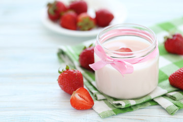 Strawberry yogurt in glass on wooden table