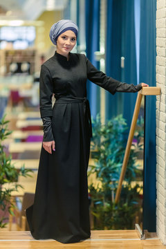 beautiful Muslim woman in a modern oriental dress standing in the foyer of the restaurant