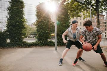 Fototapeta premium Young men playing a game of basketball