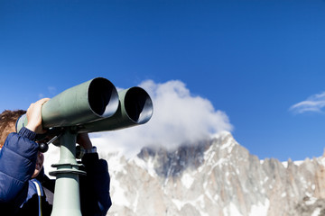 A boy looking through binoculars on the Mount Blanc 