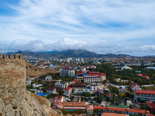 Fototapeta na wymiar View from the ramparts of the ancient to the modern buildings of the town of Sudak in Crimea
