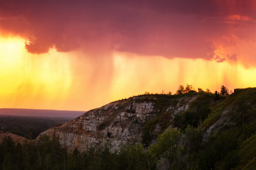 Amazing summer mountain sunset at rainy pink sky background