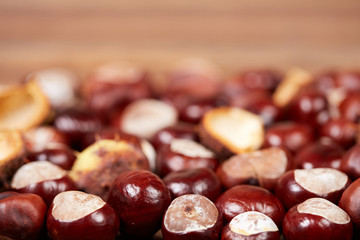 Obraz premium Chestnuts on a wooden table as autumn background