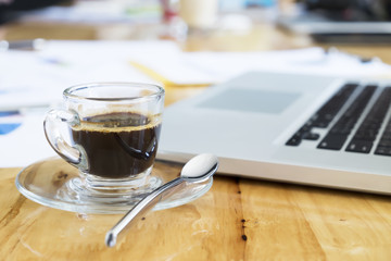 Fototapeta na wymiar Cup of coffee on working desk.