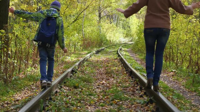 the girl and the child effortlessly go on the rails railroad