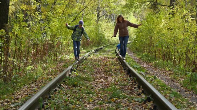 the girl with childen effortlessly go on the rails railroad