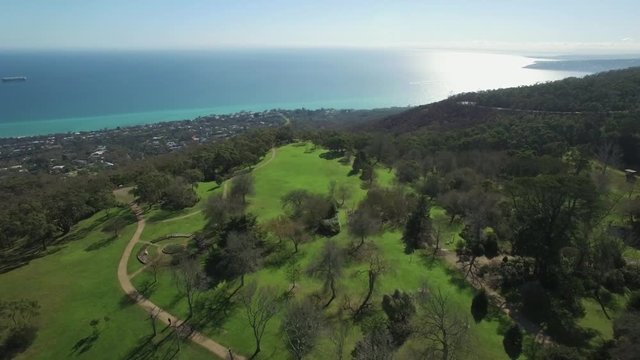 Flight over Seawinds Gardens toward suburban areas on Mornington Peninsula and Port Phillip bay on hot summer day. Melbourne, Victoria, Australia