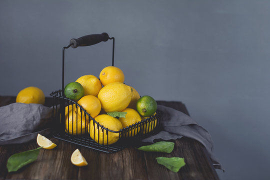 Lemon and limines in basket on wooden table