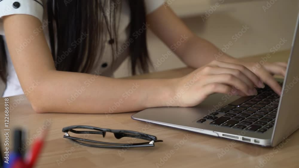 Poster women's hands typing fast on the computer entering data on keyboard. girl with natural manicure usin