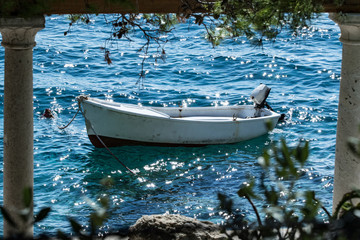 Cornice naturale con barca e mare blu.