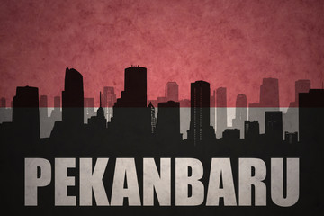 Fototapeta premium abstract silhouette of the city with text Pekanbaru at the vintage indonesian flag background