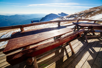 Fototapeta na wymiar Wooden tables overlooking mountain valley