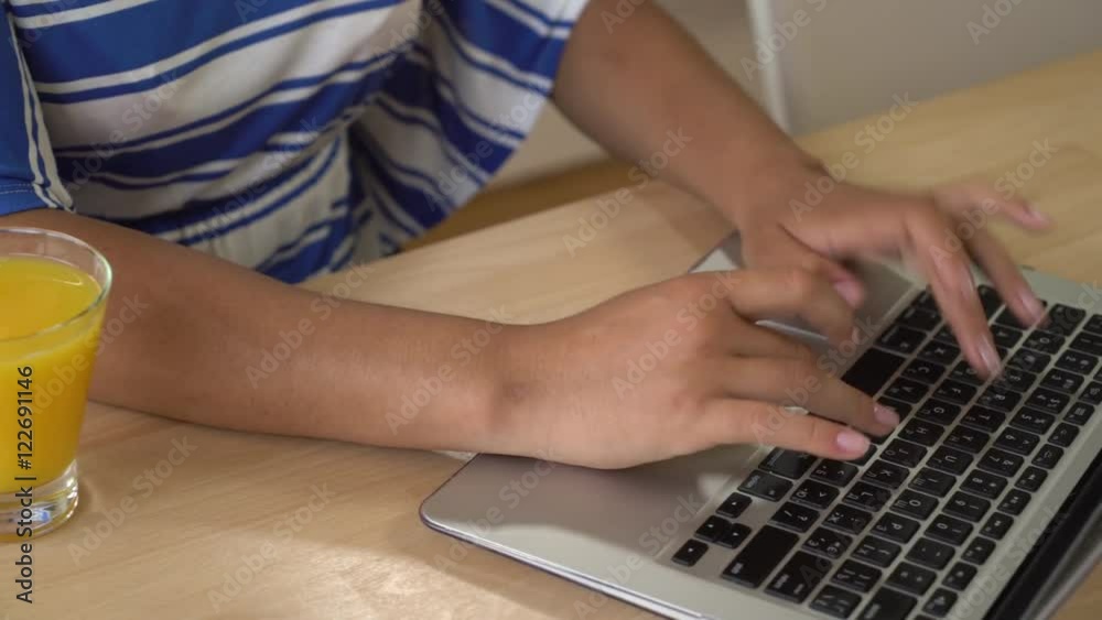 Poster woman's hands computing on computer. woman sitting at the wooden desk with pc and glass with drink o