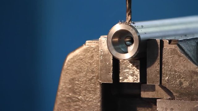 Frezy wyrzucający opiłki metalowe podczas obr&oacute;bki stalowej tulejki.