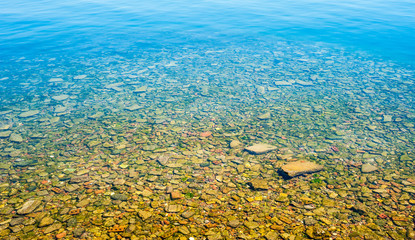 Fototapeta na wymiar Transparent shallow water with rocky bottom.
