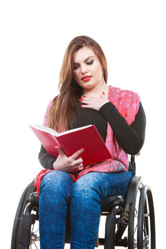Young disabled woman in wheelchair with book.