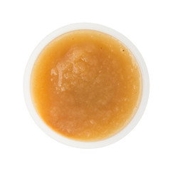 Cinnamon applesauce in a plastic container on a white background