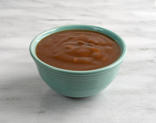 Mushroom soup with beef chunks in a bowl on a marble table side view.