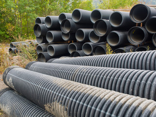 group of big  corrugated pipes made of black plastic