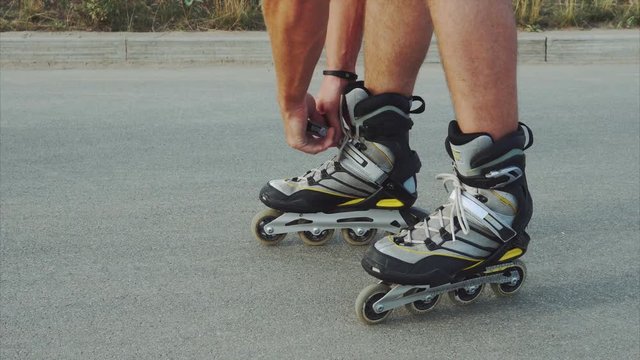 Man preparing for roller skating, putting on rollerskates 4K
