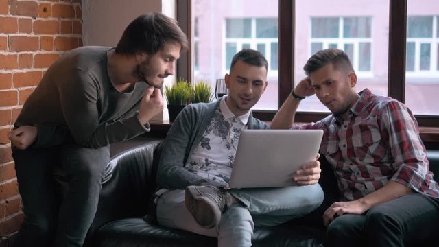Group of entrepreneurs working and taking notes together in a little office. Freelancer meeting, man with laptop drink coffee in coworking.