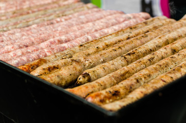Argentina barbecue asado chorizo sausages cooking on parilla grill at a street food market