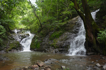 Fototapeta premium Two waterfalls cascading into a river