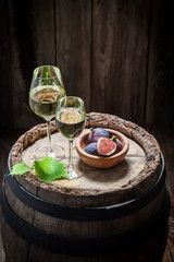 Tasty white wine with figs on old barrel