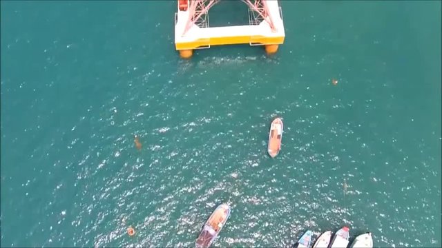 Look down to the sea surface on telpher cable car system from land to island from a fly camera