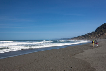 Couple Walking Along Wave-Swept California Beach