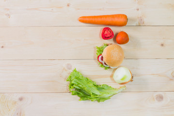 Top view hamburger and utensils on the wooden background.