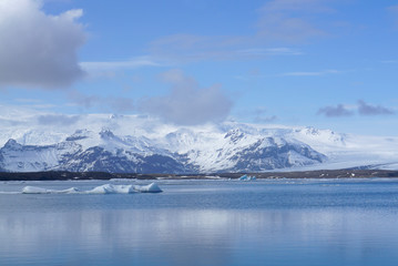 Fototapeta na wymiar ice sheet on the water with snow mountain background