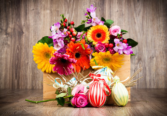 Easter eggs with flowers on wooden background