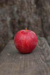 Bright red apple on a wooden background.