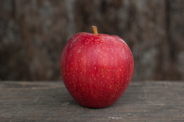 Bright red apple on a wooden background.