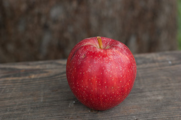Bright red apple on a wooden background.