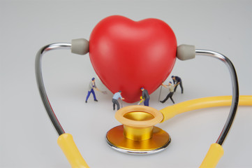 Miniature people are caring the heart
